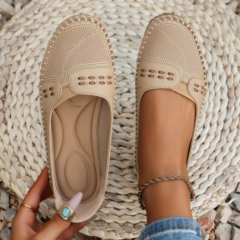 Beige women's perforated leather loafers showing the shaped insole and slip-on opening