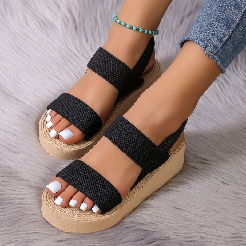 Black and beige women's platform wedge sandals with stretch straps, worn front close view