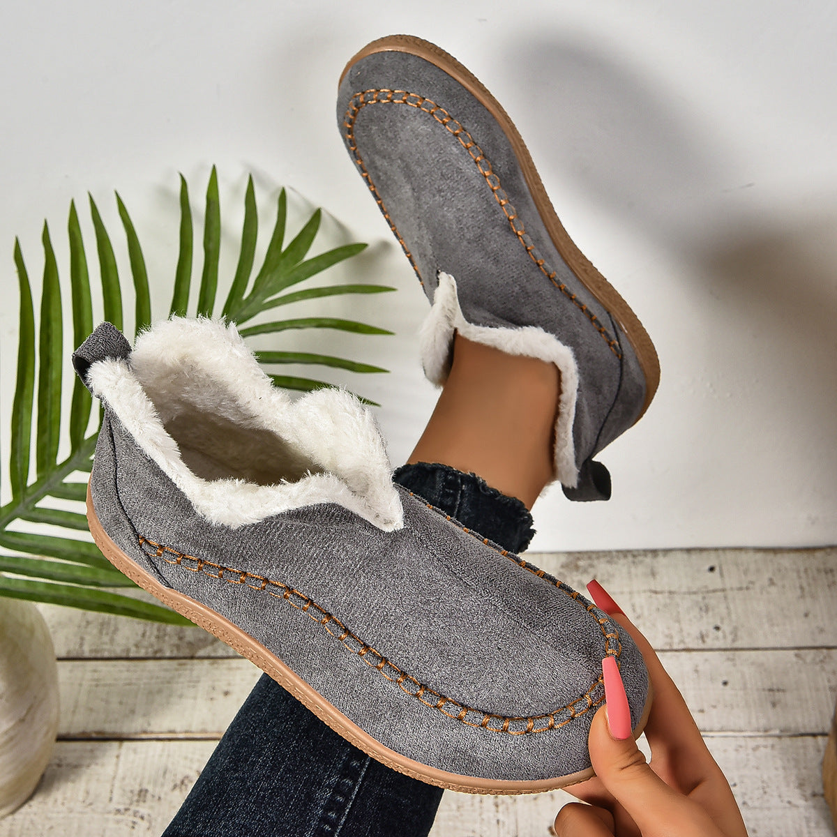 EaseLane women's fleece-lined winter slip-on shoes – grey shoe held to show the lining and sole