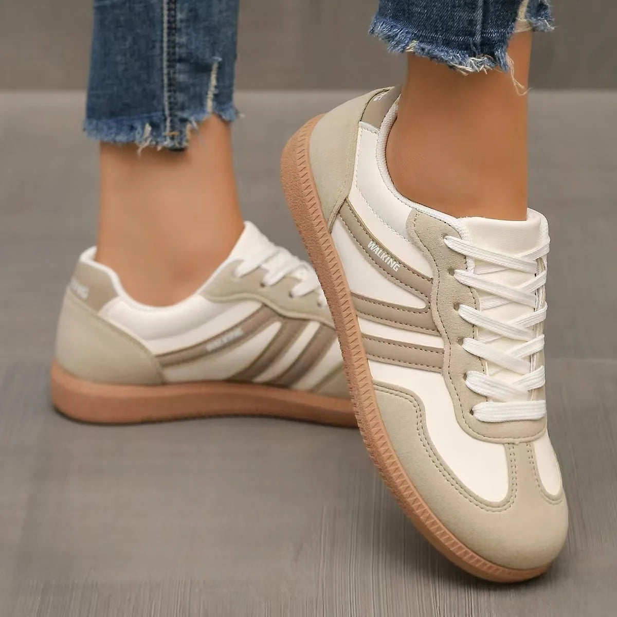 Women's beige and white retro trainers worn in a front three-quarter view