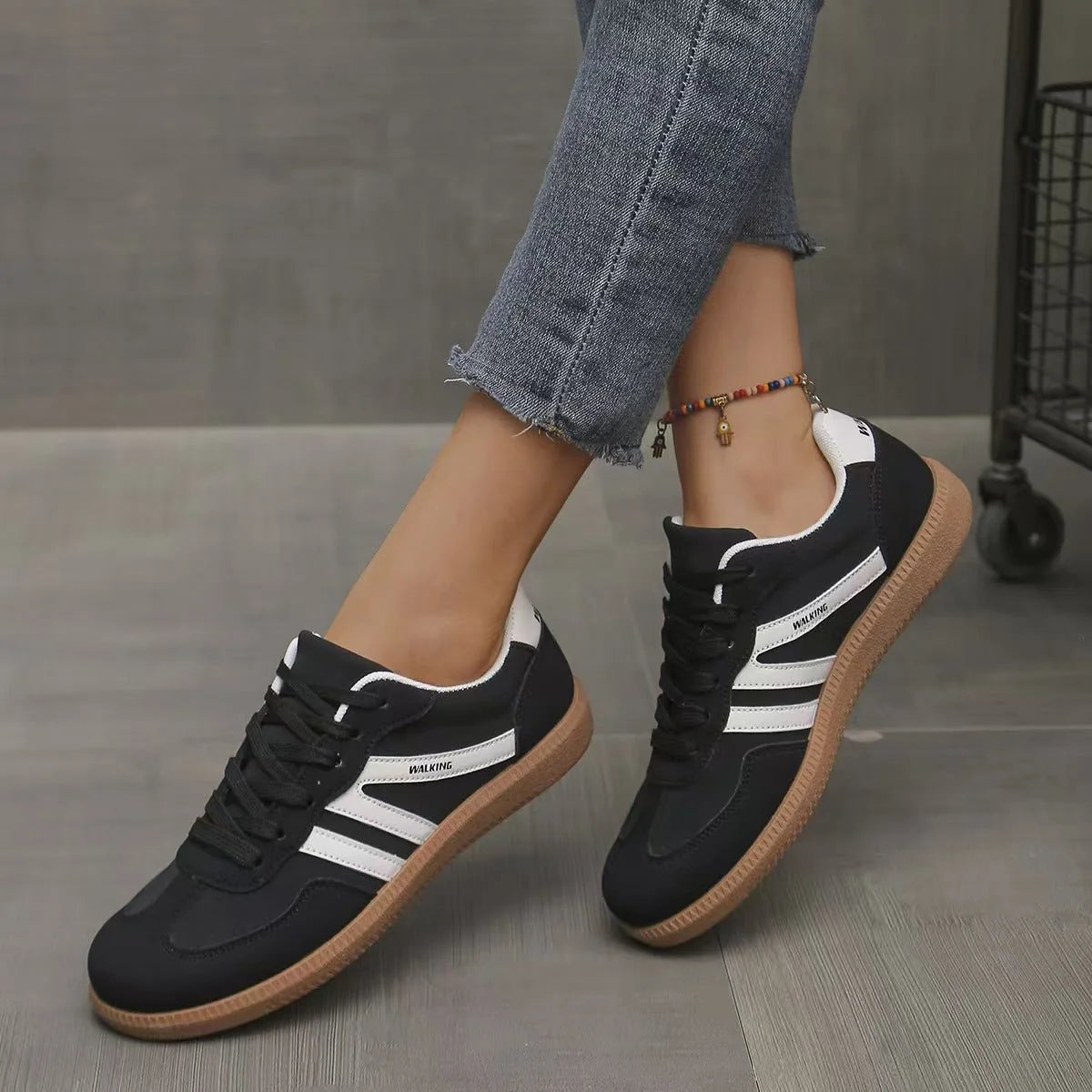 Women's black and white retro trainers worn in a front three-quarter view