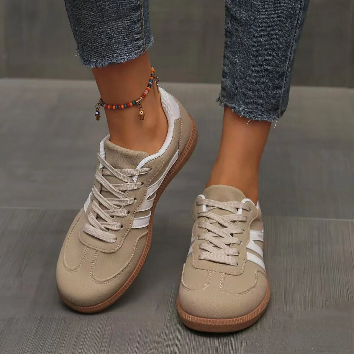 Women's beige and white retro trainers worn from the front