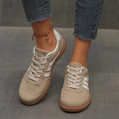 Women's beige and white retro trainers worn from the front